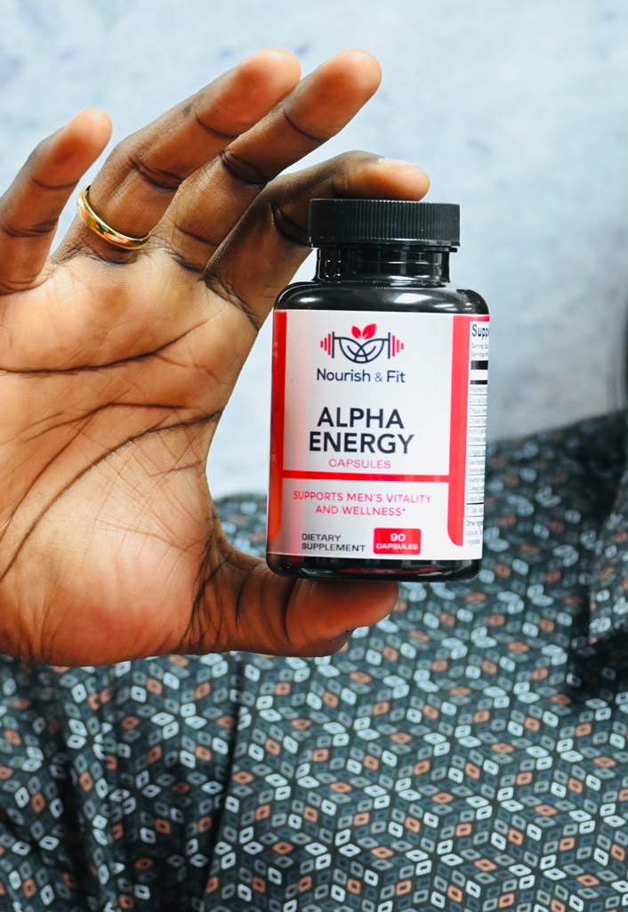 Hand holding Nourish & Fit Alpha Energy capsules, 90 count