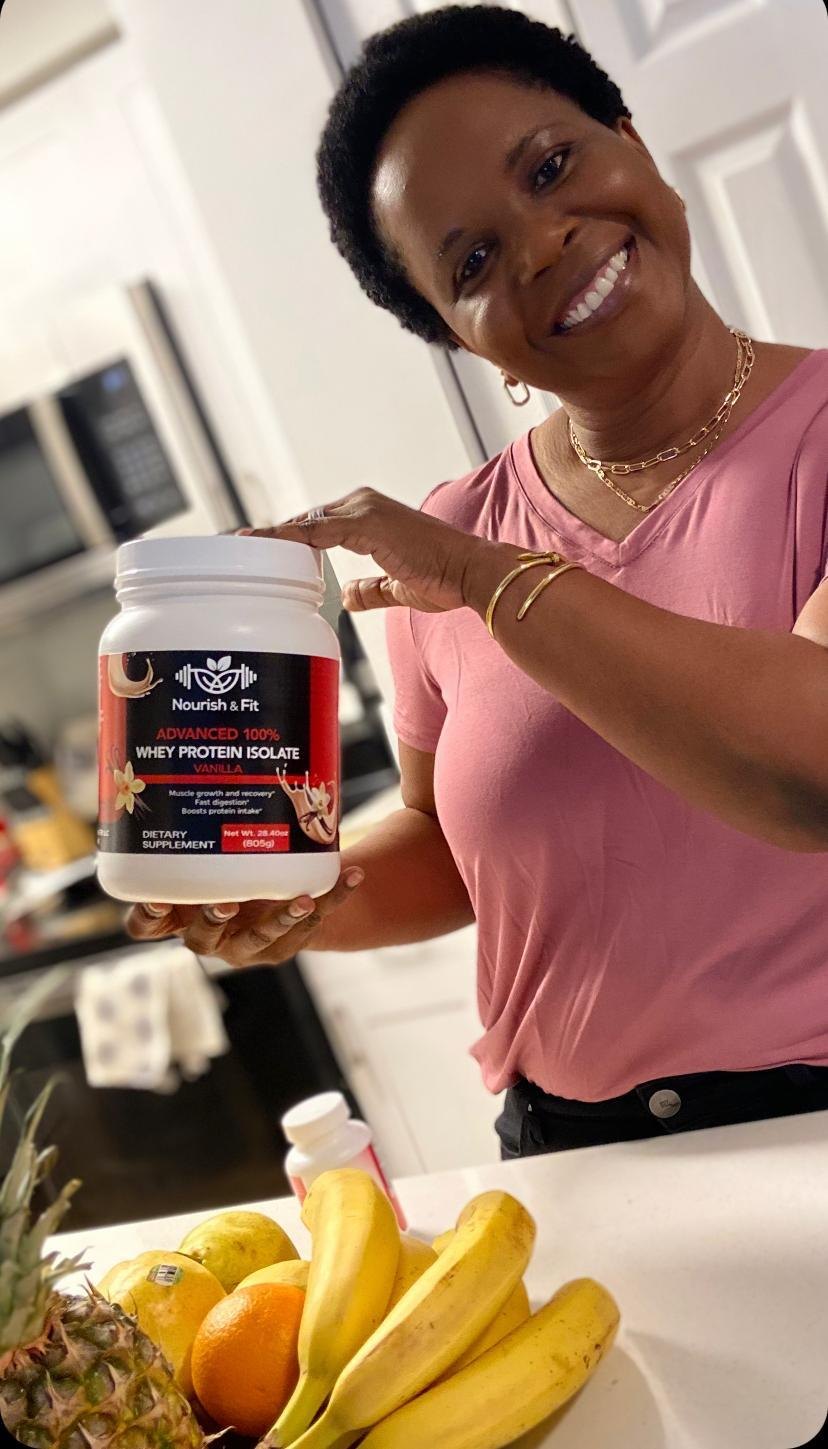 Woman holding Nourish & Fit Whey Protein Isolate Vanilla in her kitchen